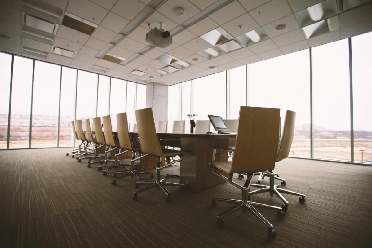 Sala de reuniones vacía con una mesa larga