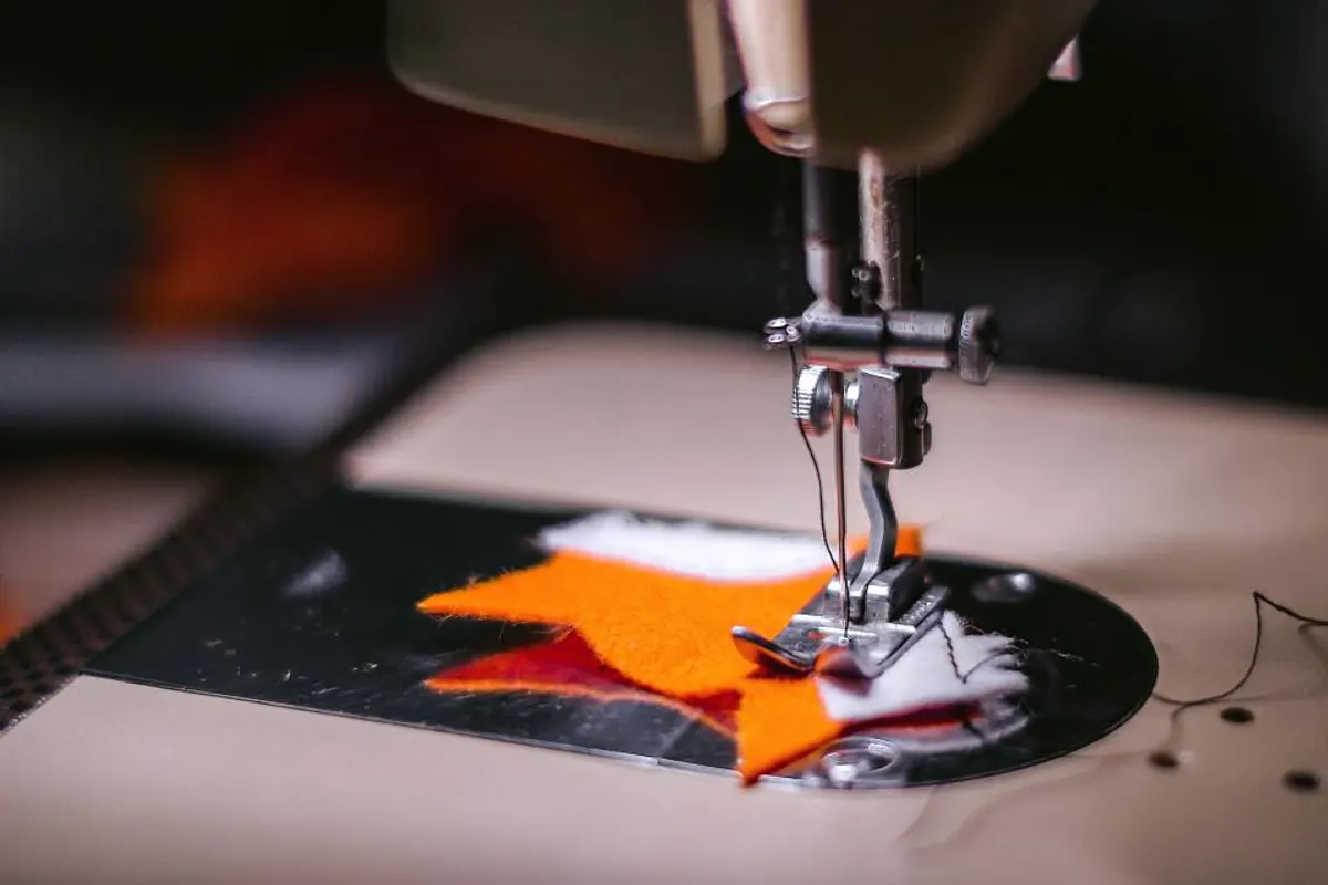 Máquina de coser trabajando sobre un tejido