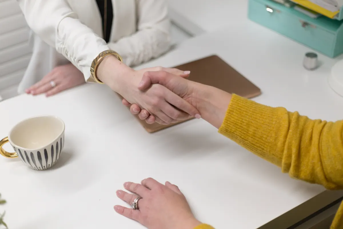 Apretón de manos sobre una mesa de trabajo