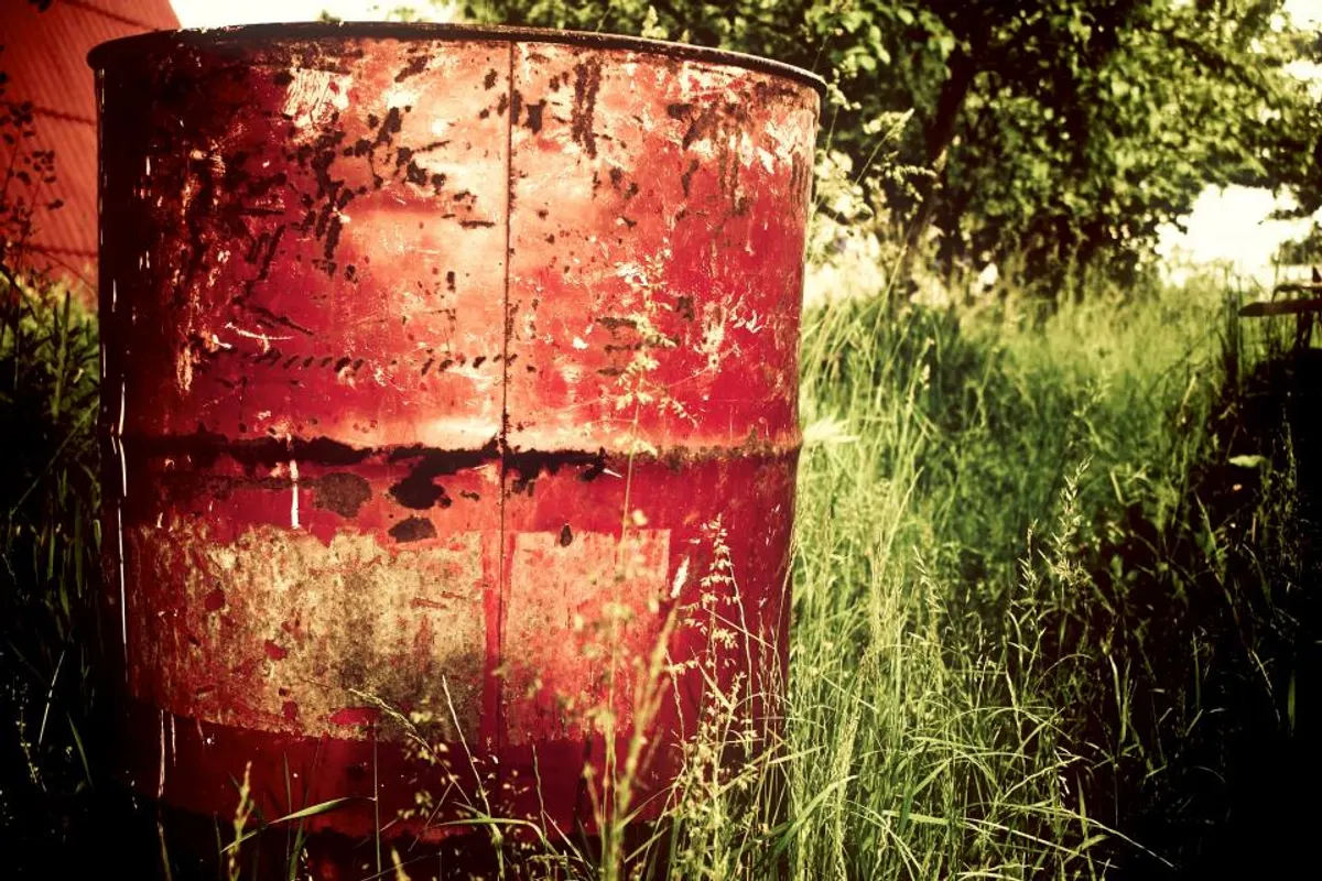 Bidón metálico rojo en un campo